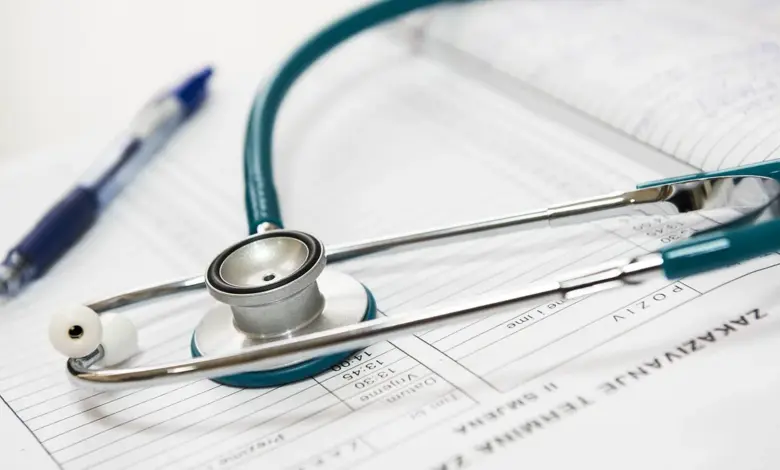 Médico preenchendo atestado no consultório, quantos dias de atestado para o ombro