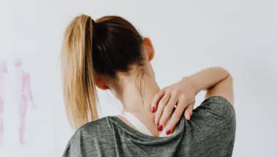 Mulher com a mão no ombro dolorido em casa, remédio caseiro para bursite no ombro